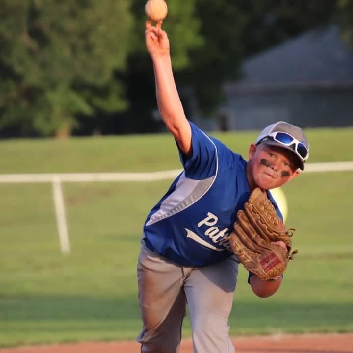Baseball player pitches in blue jersey